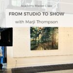 Photography studio setup with lighting rigs and a photographer filming paintings on the wall.